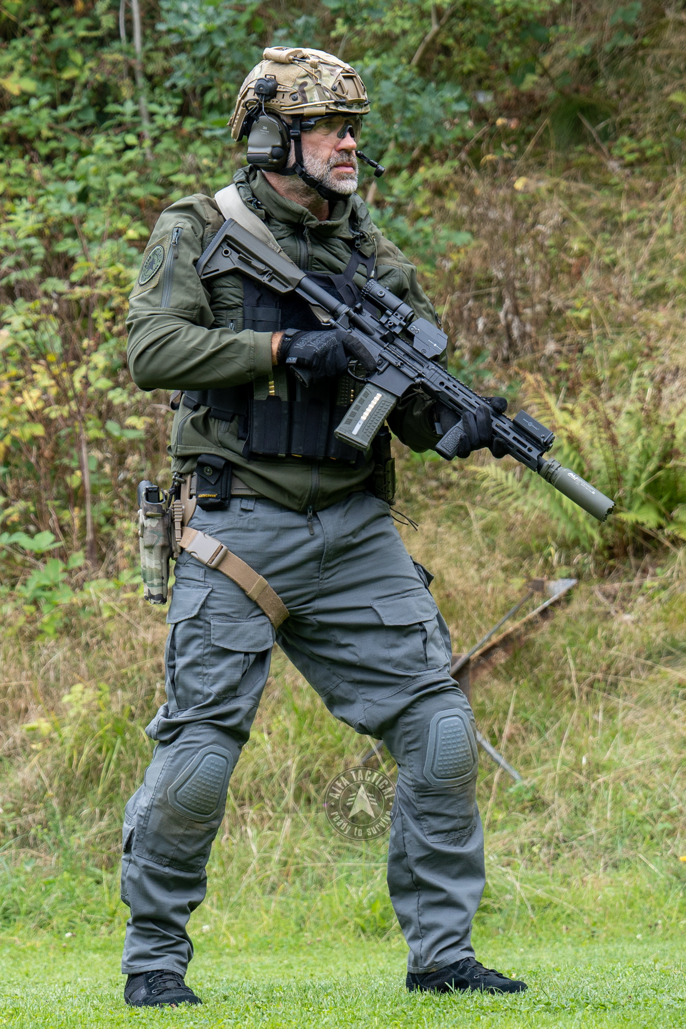 Muž v kompletní taktické výbavě — helma, vesta, puška, pistole, kalhoty a boty z nabídky Alfa Tactical